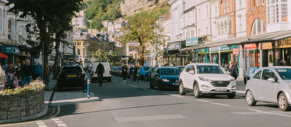 Shops and traffic along a British seaside high street on a bright day