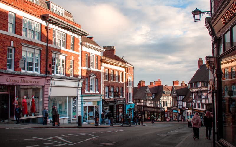 Independent shops along a red-brick and timber-framed British high street