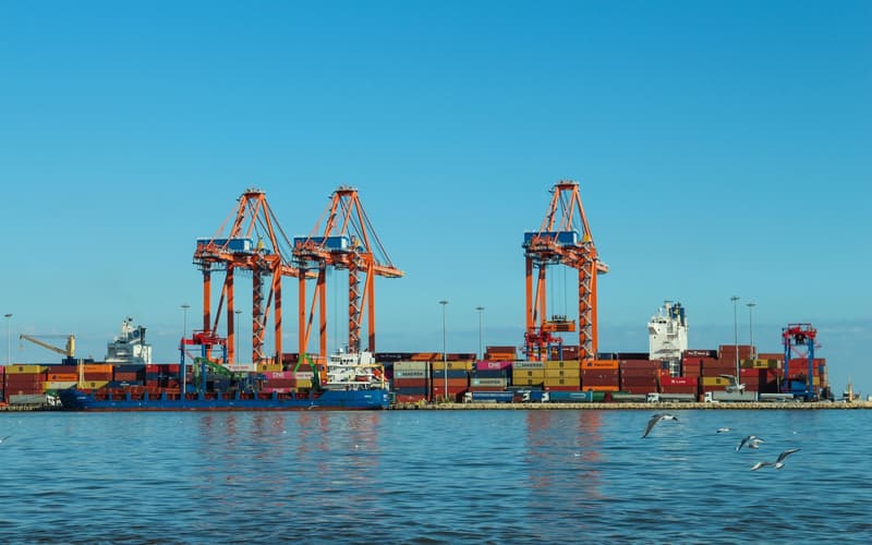 Container cranes and stacked shipping containers at a port quayside