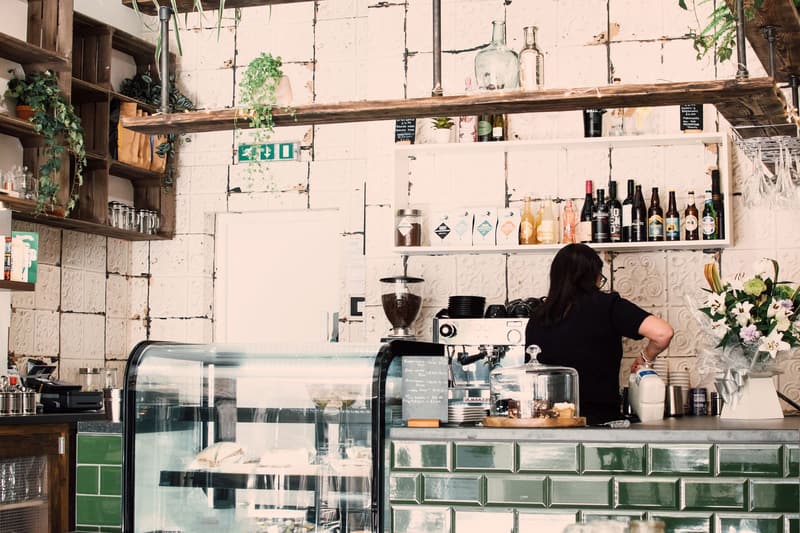 Independent café counter with green tiles and a barista at work